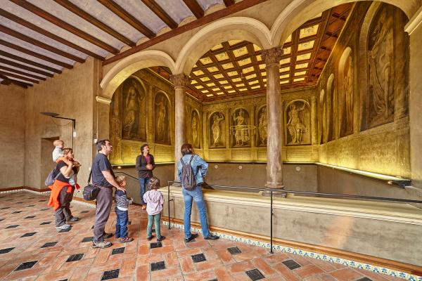 Family observing the fresco paintings inside the Palace of the Marqués de Huarte